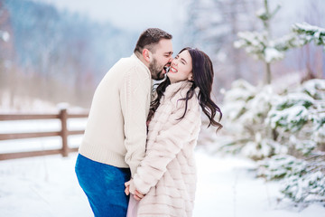 Fototapeta premium young couple on a walk in the snowy mountains