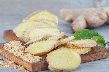 Ginger root - Fresh ginger root and sliced on wooden board