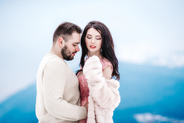 young couple on a walk in the snowy mountains