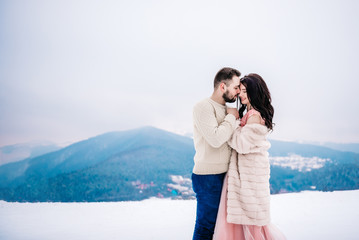 young couple on a walk in the snowy mountains