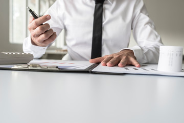 Busy financial adviser working at his business desk with many documents