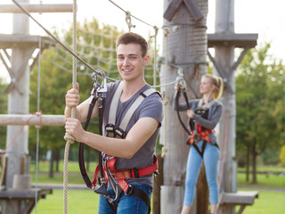 junger Mann und Frau haben Spaß beim Klettern im Kletterpark