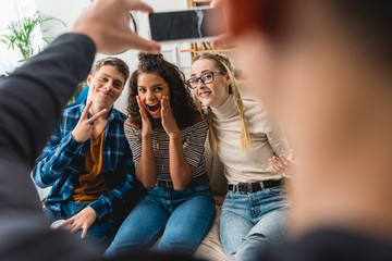 cropped image of boy taking photo of multiethnic friends