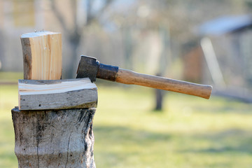 Old vintage axe is stuck in a piece of log wood used for chopping other wood.