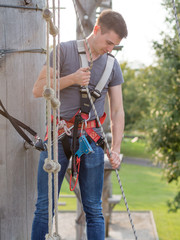 Mann sichert andere Leute mit Seil im Hochseilgarten für Sicherheit