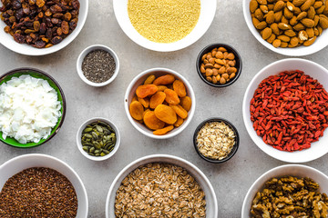 Ingredients of healthy breakfast with superfood on table, seeds, fruits, cereal, nuts, almonds, goji berries, healthy food, flat lay, overhead