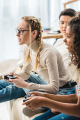 multiethnic girls playing video game at home © LIGHTFIELD STUDIOS