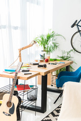 Working table and acoustic guitar at home