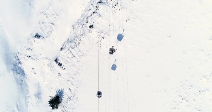 Vue a&eacute;rienne au dessus d'un t&eacute;l&eacute;si&egrave;ge dans une montagne enneig&eacute;e - neige rocher c&acirc;ble si&egrave;ge monter descendre chaine de montagne France skieur vacances tourisme voyage sport