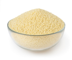 Uncooked couscous in glass bowl isolated on white background with clipping path