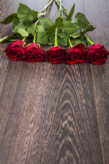 Red roses on a wooden background.