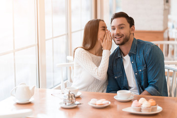 A guy and a girl are sitting together in a cafe.