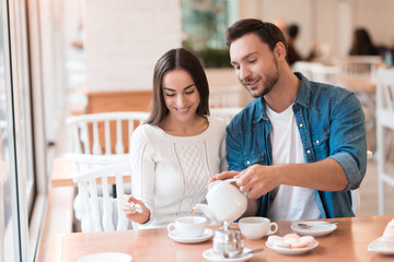 A guy and a girl are sitting together in a cafe.