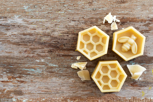 natural yellow beeswax on wooden background.