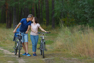 Couple kissing in forest, romantic walk on bikes