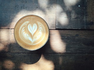 hot latte Art mini heart shape on the wooden table, vintage style 