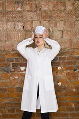 Portrait of a good looking young blond nurse with her arms crossed in a white background