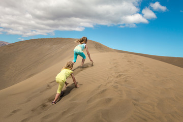 Kinder erklimmen eine Sanddüne