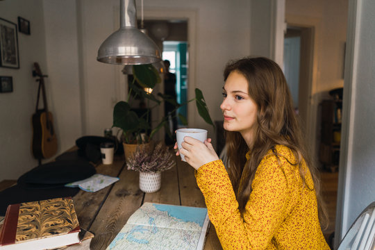 Pretty woman with cup at book