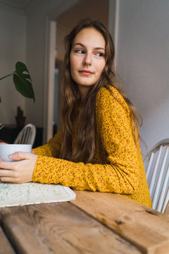 Pretty woman with cup at book