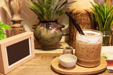 Mocha Iced coffee With fresh milk on the bottom . Placed on a wooden table ready to serve you for holidays . Customize colors Vintage retro and old film Tone .