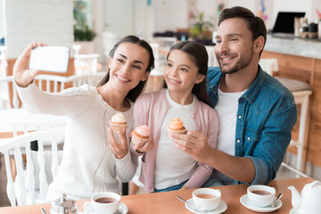 Mom takes pictures of her family on the smartphone.