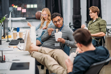 multicultural people having lunch break at modern office