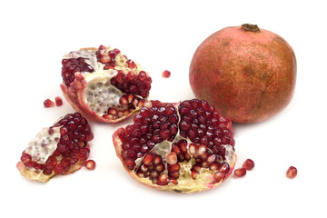 Whole and half pomegranates with ripe seeds isolated on white background front view closeup