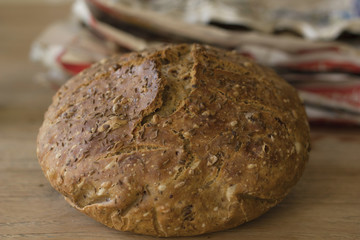 European cereal homemade loaf of bread with old newspapers on the background