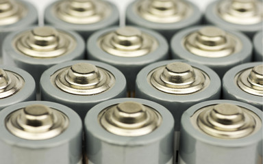 Multiple rows of standing AA batteries with blurred backgrounds