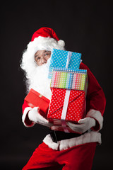 Santa Claus hold many boxes on black  background