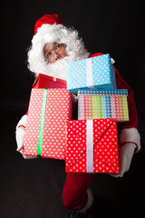 Santa Claus hold many boxes on black  background