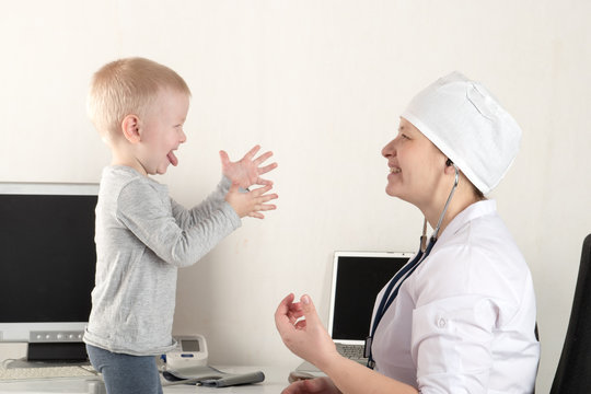 The child's doctor examines patients in his office. Happy children love a good pediatrician very much. Close up of a caucasian woman with a stethoscope. White uniform.