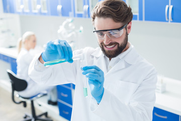 Happy delighted man working with chemical reagents