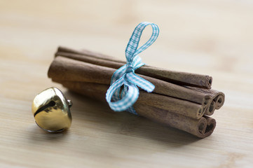 Naklejka premium Group of cinnamon tied with checkered light blue bow, golden jingle bell