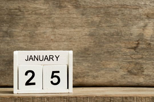 White block calendar present date 25 and month January on wood background