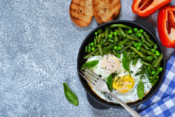 Homemade light breakfast. Scrambled eggs with asparagus and green peas. Crispy baguette grill.