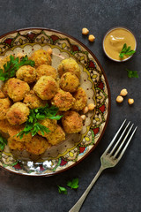 Arabian dish - falafel with sauce and cilantro on a black background.