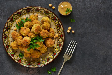 Arabian dish - falafel with sauce and cilantro on a black background.