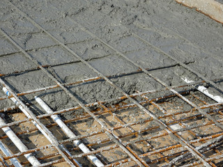 The wet concrete poured on a steel reinforcement bar to form strong floor slabs called reinforce...