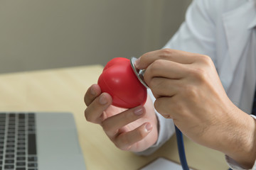 Doctor hand holding stethoscope and red heart in hands.Check up heart concept