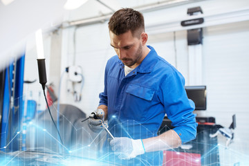 mechanic man with wrench repairing car at workshop