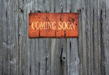 Rusty metal sign with the phrase: Coming soon.