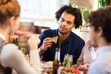 man with friends eating at restaurant