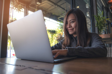 Closeup image of a beautiful Asian business woman looking , working and typing on laptop keyboard in office