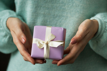 Beautiful female hands with packaged cute gift