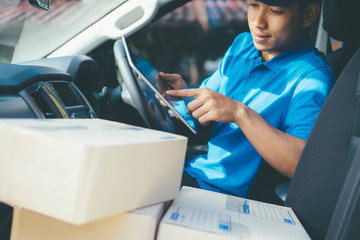 Young Delivery Man Checking Customer List On Tablet.