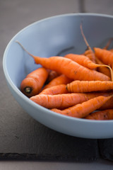 Small baby carrots in soup plates close up