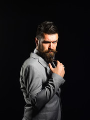 Businessman with strict or evil face isolated on black background.