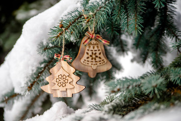 Wooden Christmas toys hanging on the branches of the Christmas tree